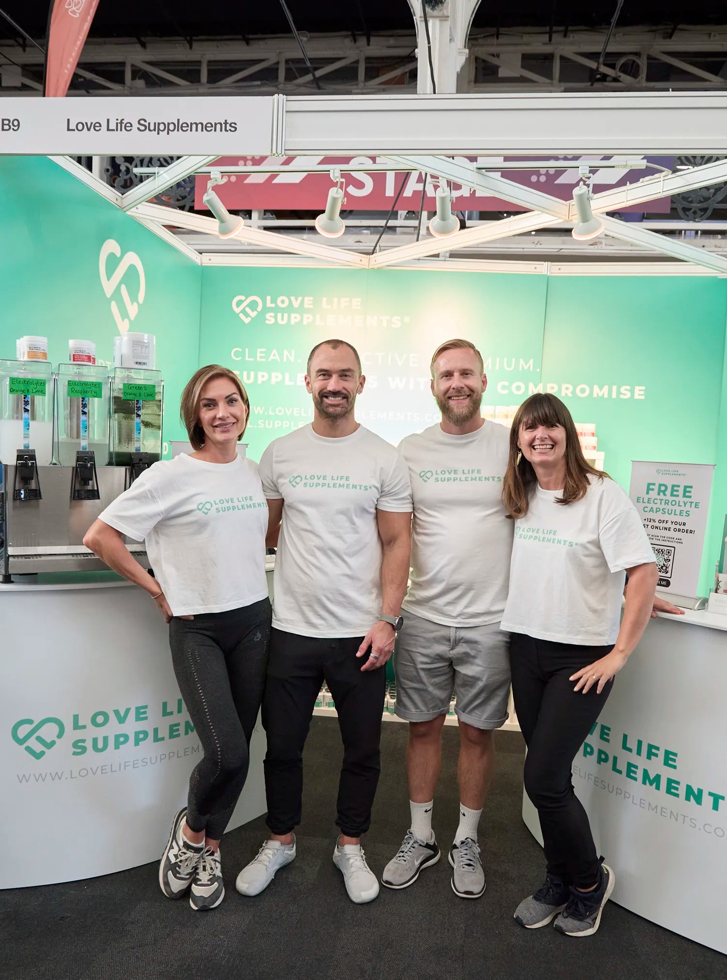 love life supplements team Four people standing in front of a Love Life Supplements booth at an event.